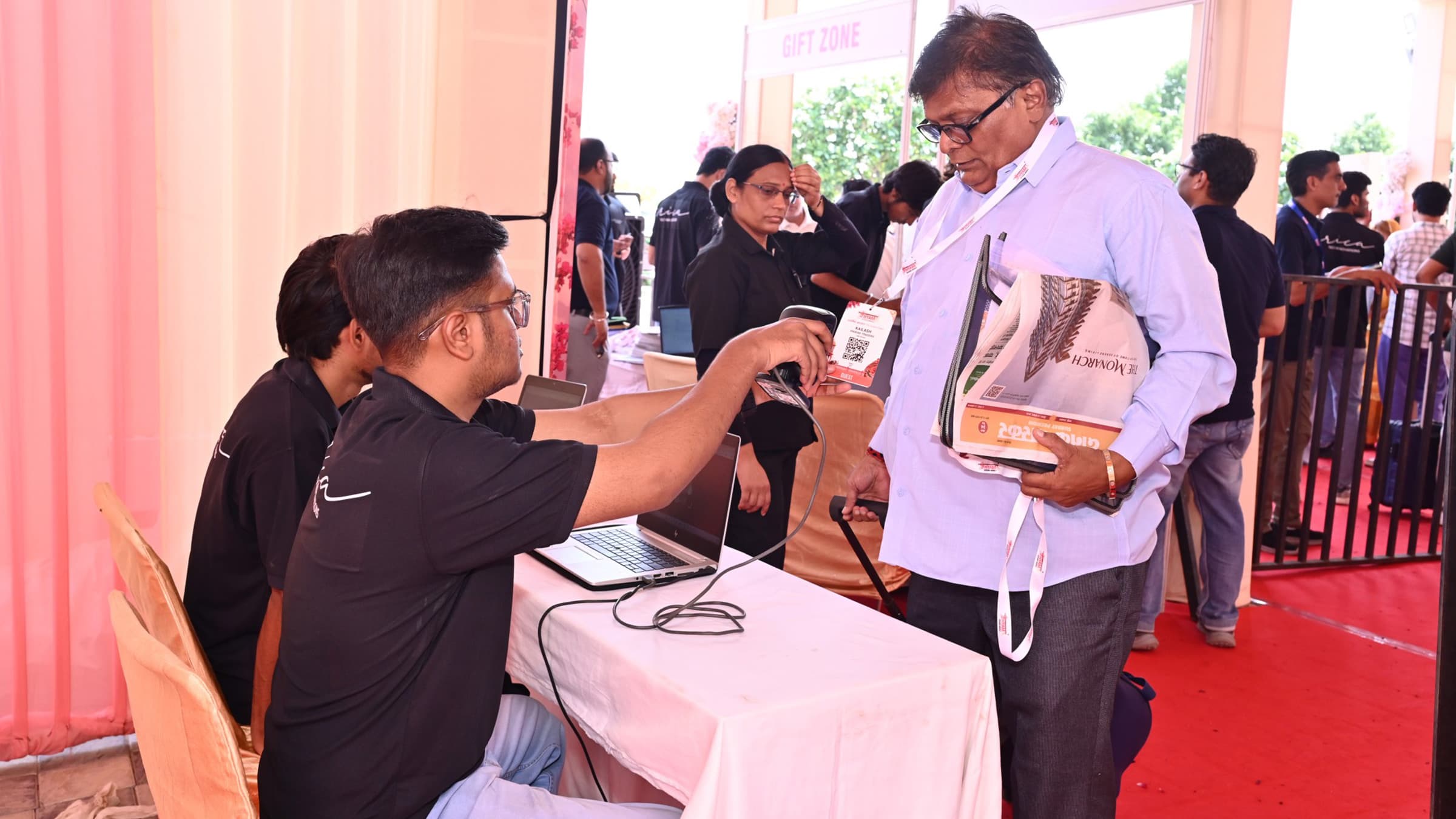 Staff at a laptop serving a guest at a Swarnim Adhyay counter
